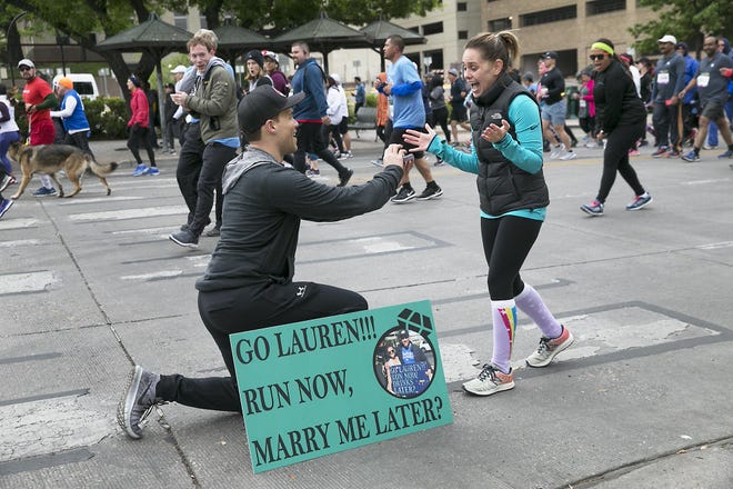 Daniel Chavez faked an injury to get out of running the 41st annual Capitol 10,000 so he could propose to his girlfriend Lauren Crunk in front of the Texas Capitol Sunday morning as she ran the race with friends. He greeted her with a sign he held last year when they met for the first time at the same race. She said yes in tears and to cheers from fellow runners. [Ralph Barrera/American-Statesman]
